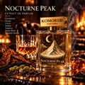 Nocturne Peak Extrait de Parfum by Komorebi Parfums in a warm amber lounge, engraved mountain and single crescent moon